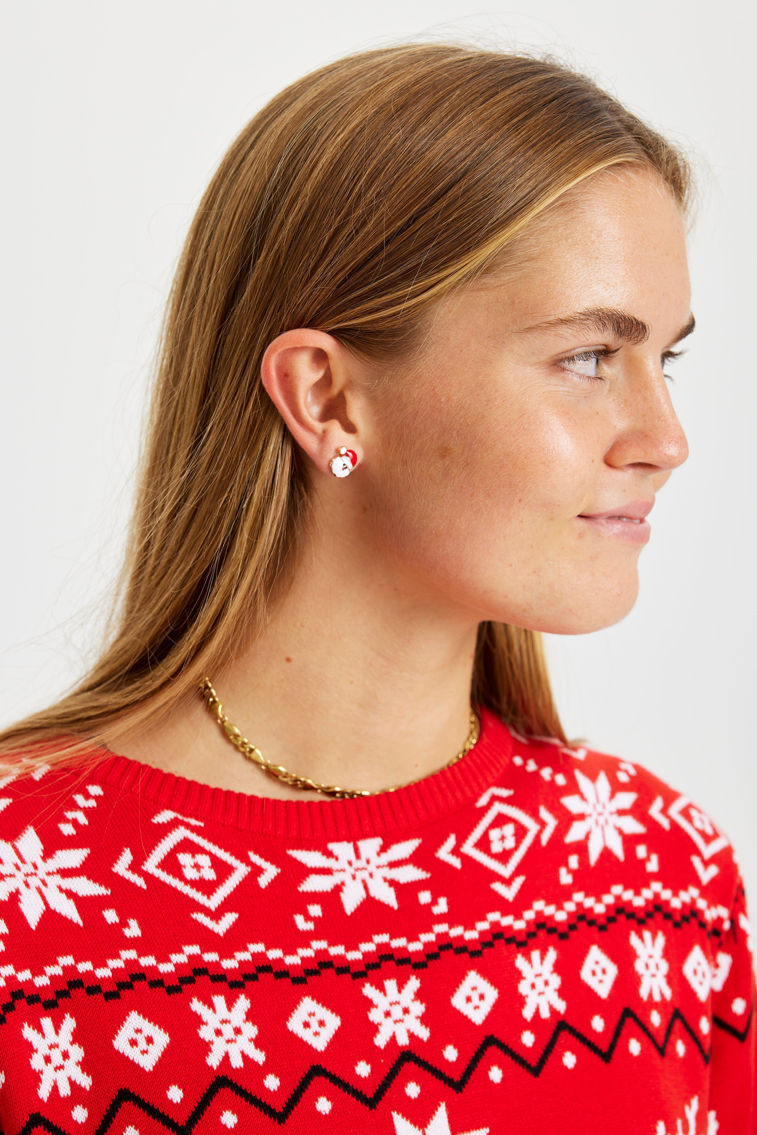 Een lachende vrouw met kerstoorbellen.